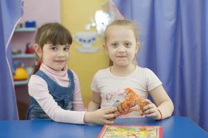 deux six année vieux les filles avec une jouet. copines dans Jardin d'enfants. photo