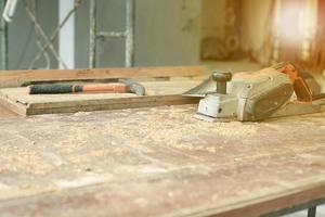 Mise au point sélective sur les outils de menuiserie sur le bureau en bois sale avec de la sciure de bois photo