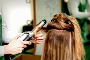 coiffeur curling cheveux avec curling le fer photo