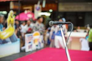 mise au point sélective sur le microphone sur scène avec foule floue de personnes en arrière-plan photo