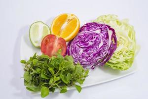 une assiette de des légumes et Frais citron vert et citron. photo