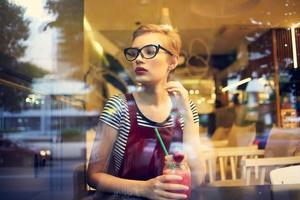 femme avec court cheveux dans une restaurant avec cocktail du repos boisson photo