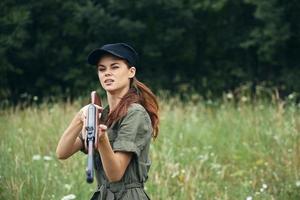 femme sur la nature femme en portant une pistolet Regardez vers l'avant chasse noir casquette photo