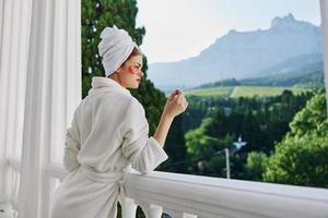 sensuel et magnifique femme dans une peignoir des stands sur un ouvert balcon parfait ensoleillé Matin photo