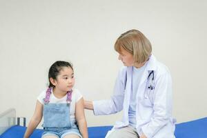 femme médecin soutien acclamer petite fille mignonne examiner consulter à l'hôpital, enfant en consultation chez le pédiatre. concepts de santé et de médecine photo