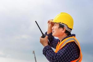 ingénieur homme en dessous de inspection et vérification projet à le bâtiment placer, contremaître ouvrier dans casque à le Infrastructure construction site photo