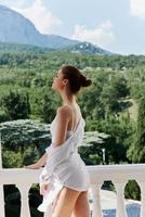 portrait de Jeune magnifique femme des stands sur une balcon terrasse dans lingerie lumière du soleil magnifique vue relaxation concept photo