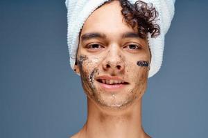 gars avec une serviette sur le sien tête produits de beauté peau se soucier fermer photo