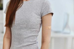 femme T-shirt avec adhésif plâtre sur épaule immunité santé convoitise passeport photo