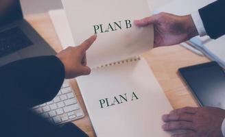 plan, plan B concept, homme d'affaire travail sur table avec ordinateur portable téléphone intelligent clavier et papier. affaires Planification photo