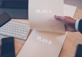 plan, plan B concept, homme d'affaire travail sur table avec ordinateur portable téléphone intelligent clavier et papier. affaires Planification photo