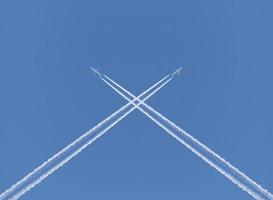 traversée de deux avion traces dans une bleu ciel photo