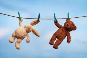 peluche jouets lapin et nounours ours sont séché sur une corde à linge après la lessive photo