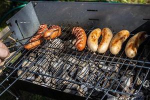 chaud saucisses mensonge sur une chaud gril fermer à l'extérieur photo