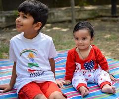 deux content garçons dans société parc, content asiatique frères qui sont souriant Heureusement ensemble. frères jouer en plein air dans été, meilleur amis. bambin bébé garçon en jouant avec le sien content frère dans le jardin photo