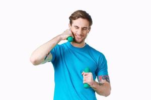 homme avec haltères dans le sien mains bleu T-shirt exercice aptitude écouteurs photo