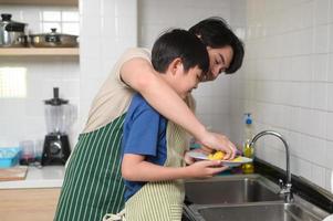 content souriant Jeune asiatique père et fils la lessive vaisselle dans cuisine à Accueil photo