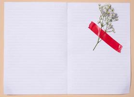 vide blanc feuille de papier et gypsophilie fleurs sur une beige arrière-plan, espace pour un une inscription photo