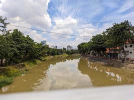 une vue de marron rivière avec bleu ciel et des arbres à côté de il dans surabaya, Indonésie photo