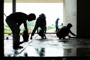 Groupe de silhouette de travailleurs dans la maison en construction