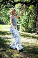 magnifique et de bonne humeur adulte femme pratiquant tai chi dans parc. photo