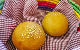 délicieux petits pains ronds aux graines de sésame sur table en bois mexique. photo