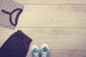 T-shirt avec un pantalon et des chaussures sur fond de bois photo