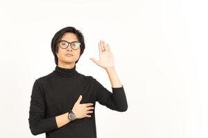 main sur poitrine et Faire jurant geste de Beau asiatique homme isolé sur blanc Contexte photo
