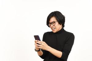 en portant et en utilisant téléphone intelligent avec en colère visage de Beau asiatique homme isolé sur blanc Contexte photo