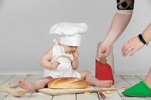en train de préparer pour une photo tirer sur votre premier anniversaire. une enfant dans une cuisinier costume est en train de préparer pour une photo tirer