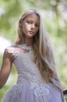 magnifique adolescent fille dans une blanc robe sur une Contexte de verdure photo