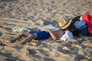 le enfant mensonges sur le plage dans le sable. le garçon est tombée endormi sur le plage. photo