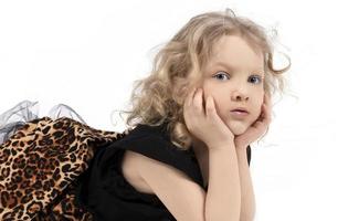 magnifique enfant. le peu aux yeux bleus blond mensonges sur une blanc Contexte. cinq année vieux fille. beauté enfant modèle. enfant d'âge préscolaire. photo