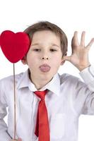 enfant avec Valentin. une garçon avec une rouge cœur grimaces. photo