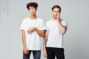 deux de bonne humeur copains dans blanc t-shirts émotions positif lumière Contexte photo