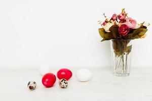vacances de lumière Pâques et peint des œufs sur le table une bouquet de fleurs dans une vase photo