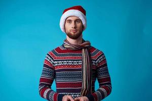 de bonne humeur homme dans une Père Noël chapeau avec une téléphone dans le sien mains isolé Contexte photo