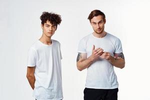 deux Hommes dans blanc t-shirts émotions relation amicale amusement photo