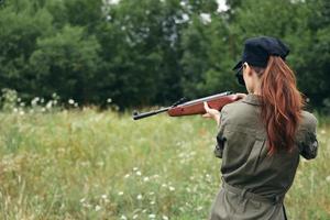 femme sur Extérieur armes dans main la nature Frais air chasse vert feuilles photo