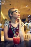 femme avec court coiffure dans une café cocktail du repos pensif Regardez photo