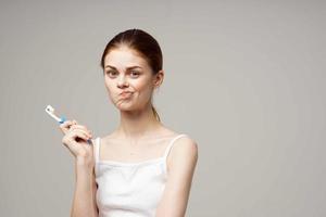 de bonne humeur femme avec une brosse à dents dans main Matin hygiène lumière Contexte photo