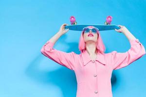 à la mode femme dans des lunettes de soleil porte une rose perruque isolé Contexte photo