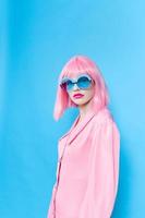 glamour femme dans rose robe avec bleu des lunettes studio photo