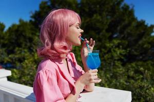 Enchanté Jeune fille en buvant une cocktail sur le terrasse inchangé photo