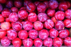 texture de rouge prune dans magasin proche en haut Haut view.box avec prunes dans boutique .savoureux sucré fruit pour dessert, salade ,jus photo