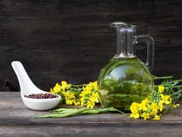 canola huile, fleurs et des graines sur rustique bois photo