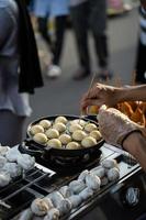 nourriture vendeurs fabrication takoyaki, une délicieux rue nourriture casse-croûte à le Jogokariyan ramadhan marché photo