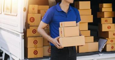 boîtes à colis sur étagère et sacs à provisions de couleur placés près d'un ordinateur portable sur la table. PME sur les achats en ligne au bureau à domicile l'emballage en arrière-plan est une entreprise populaire. photo