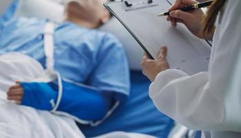 homme avec cassé bras dans jeter mensonge sur lit dans hôpital. le urgence centre traitement est plâtre et bloque avec fronde pour une plus loin guérir dans un orthopédique clinique. patient douleur de accident blessure. photo