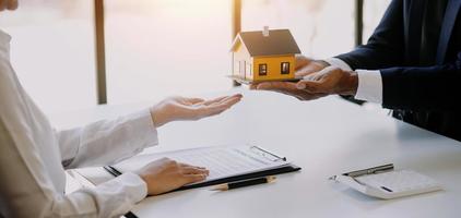 agent de courtage immobilier présentant et consultant le client pour la prise de décision signant un accord de formulaire d'assurance, modèle d'achat et de vente de maison, concernant l'offre de prêt hypothécaire et l'assurance habitation photo